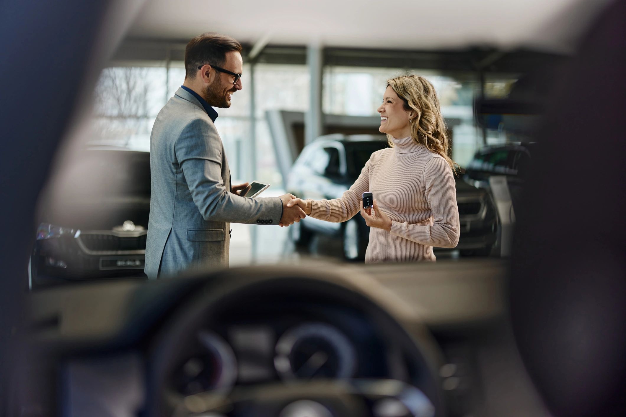 Customer and salesperson discussing a vehicle in a showroom