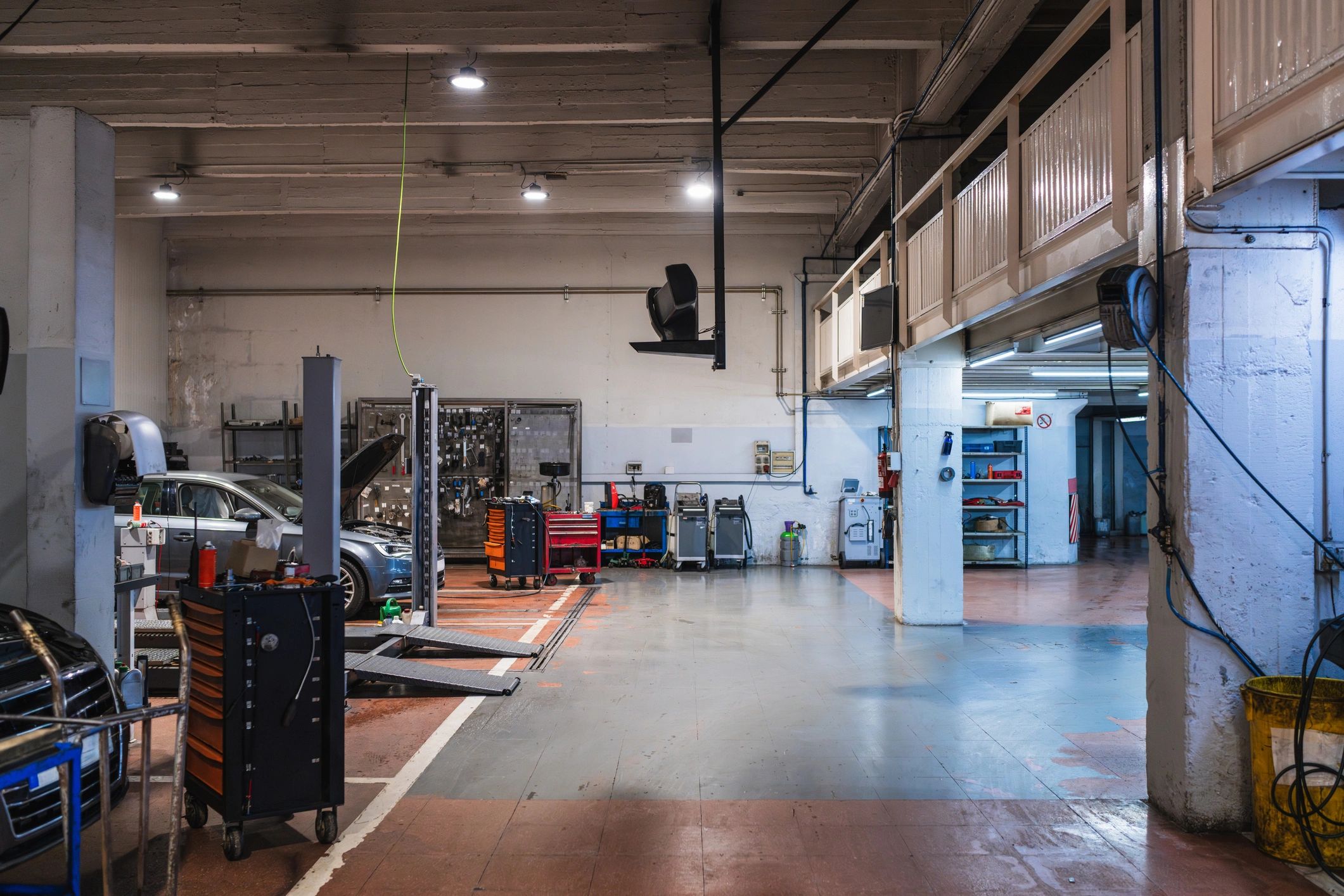 Car on a lift inside a clean auto repair shop service bay